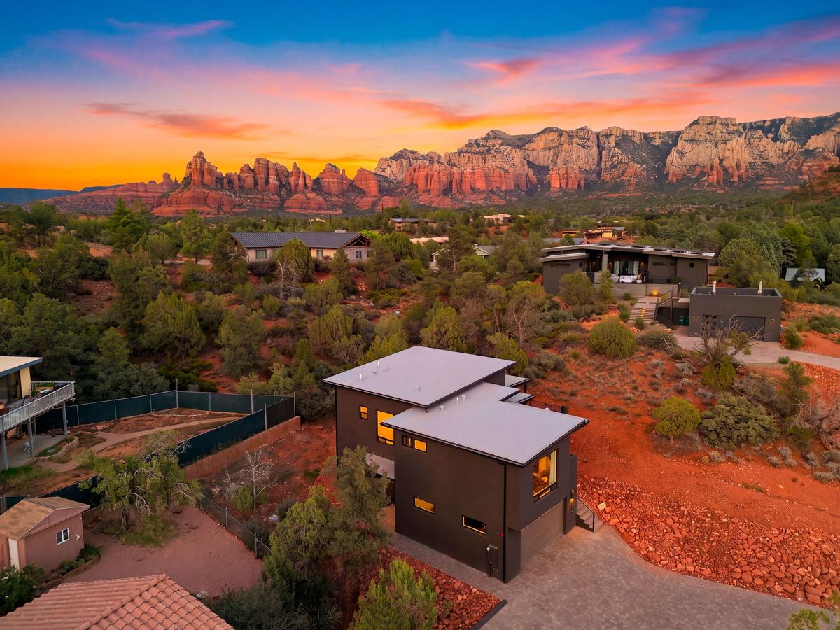 Aerial view of the house at sunset with Sedona's red rock skyline behind it.