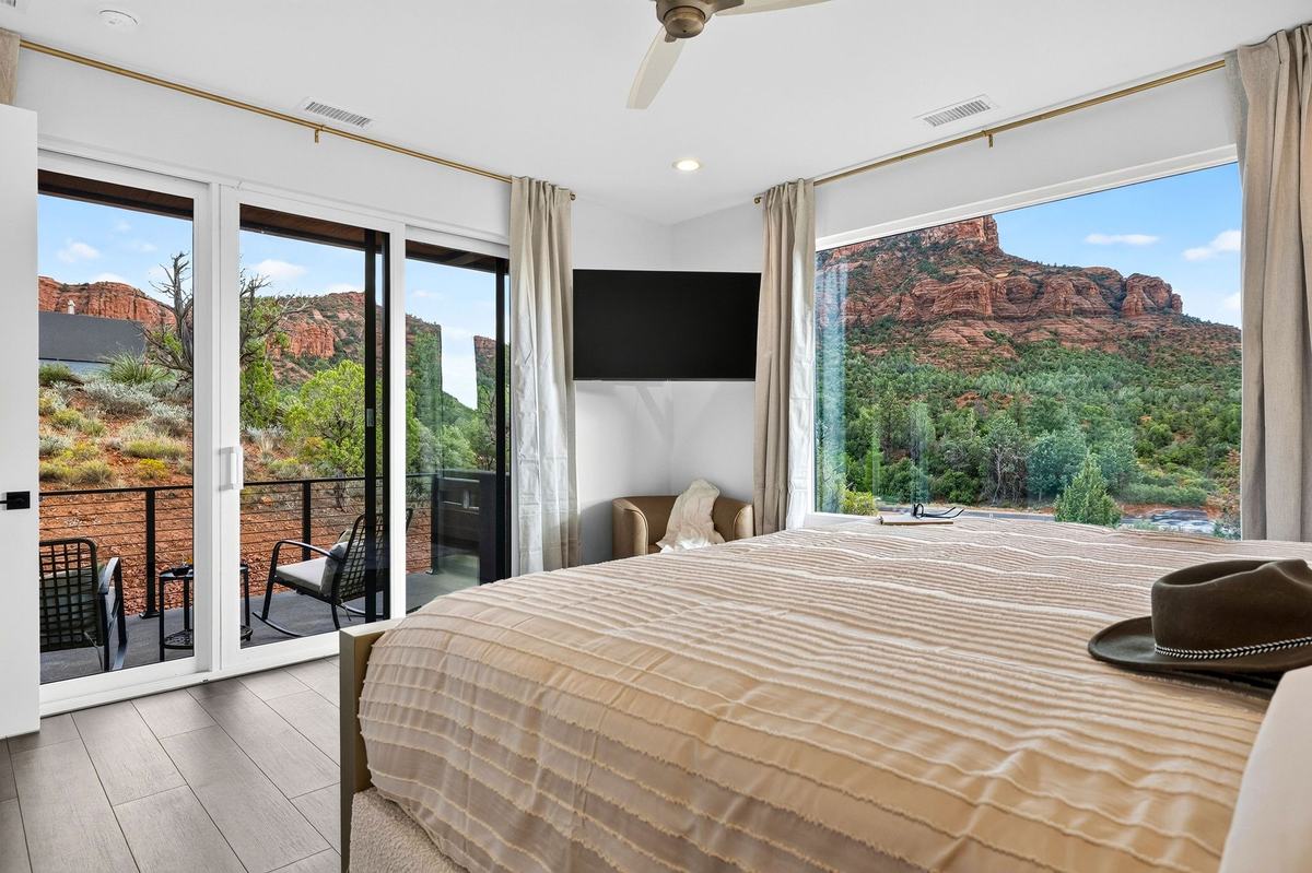 Primary bedroom with a king bed, sliding doors to the deck, and a red rock view.