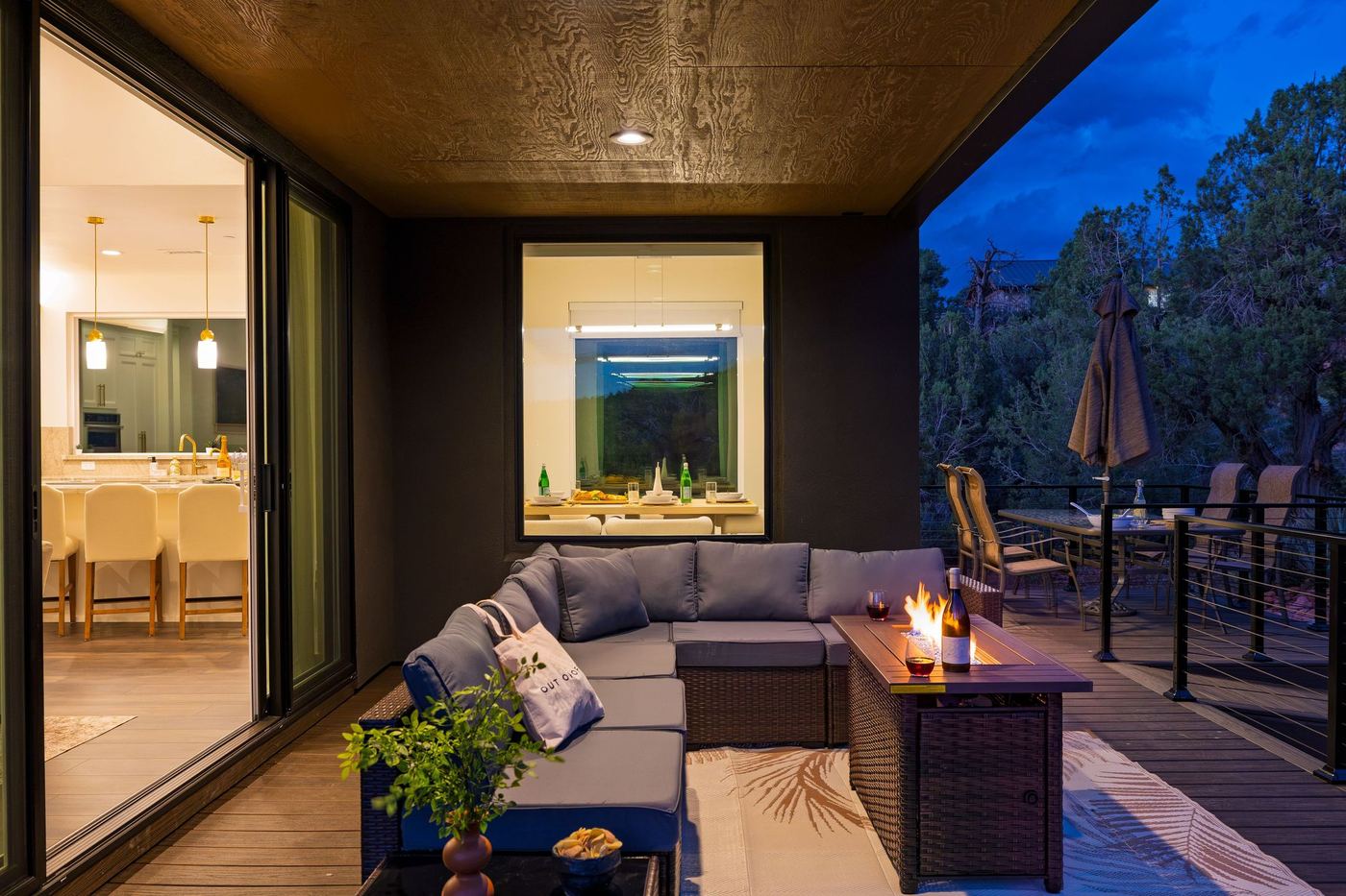 The covered lounge at dusk with the fire table lit.